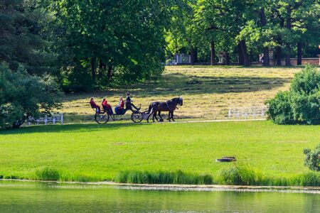 Pushkin, Russia - June 28, 2019: Tourists ride a horse-drawn carriage in Catherine park at Tsarskoe...