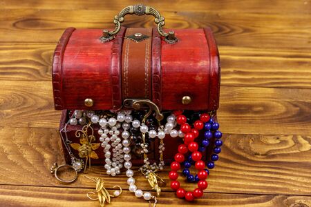 Vintage treasure chest full of jewelry and accessories on wooden backgroundの写真素材
