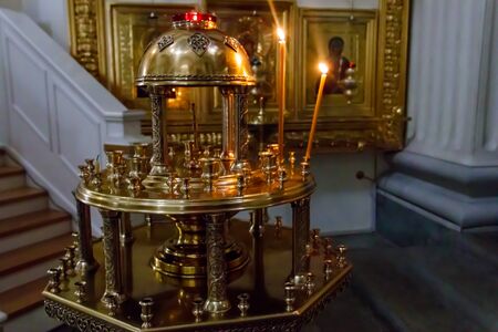 Large church golden candlestick with burning candles in orthodox church