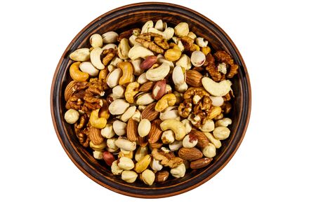 Bowl with mixed nuts isolated on white background. Walnuts, pistachio, almond, peanut, cashew, hazelnut in ceramic bowl. Top viewの写真素材