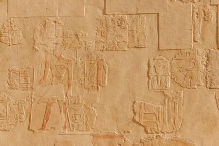 Ancient egyptian paintings and hieroglyphs on a wall in Mortuary temple of Hatshepsut in Luxor, Egyptの写真素材