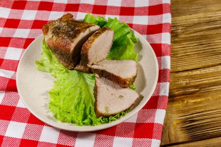 Tasty baked pork with spices on a wooden tableの写真素材