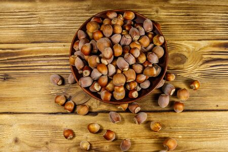 Hazelnuts in ceramic plate on a wooden table. Top viewの写真素材