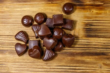 Tasty chocolate candies on wooden table. Top view