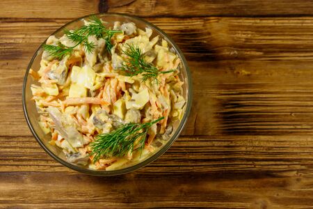 Tasty salad with chicken breast, roasted mushrooms, carrots, grated cheese, eggs and mayonnaise on wooden table. Top viewの写真素材