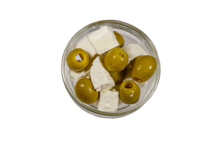 Feta cheese cubes with green olives in glass bowl isolated on white background. Top viewの写真素材