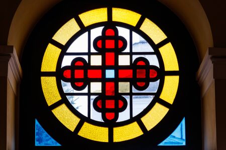 Old stained glass window with cross in old cathedralの写真素材