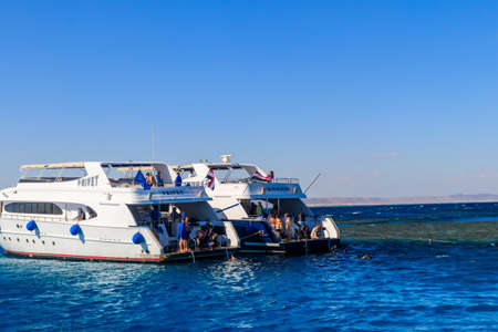 Hurghada, Egypt - December 7, 2018: Unknown people snorkeling over the coral reef and resting on...