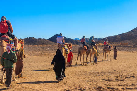 Hurghada, Egypt - December 10, 2018: Group of tourists riding camels in Arabian desert, Egyptのeditorial素材