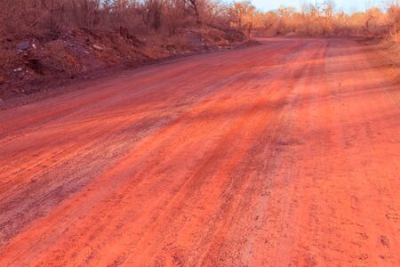 Red dirt road polluted with iron ore near iron ore quarry in Kryvyi Rih, Ukraineの写真素材