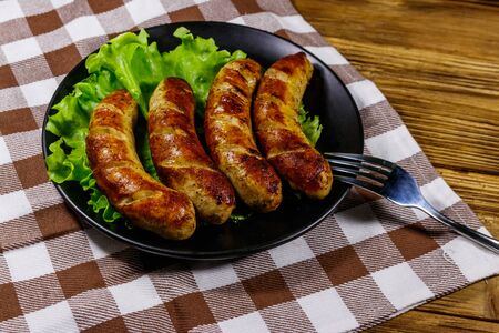 Tasty grilled sausages on a wooden tableの写真素材