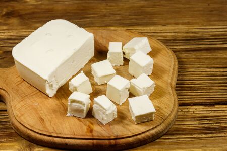 Feta cheese on cutting board on a wooden tableの写真素材