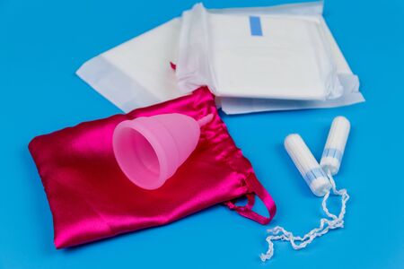 Sanitary pad, tampons and menstrual cup on blue background. Concept of critical days, menstruation, feminine hygieneの写真素材