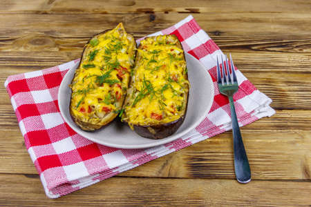 Baked stuffed eggplants on a wooden table. Healthy food and dieting concept