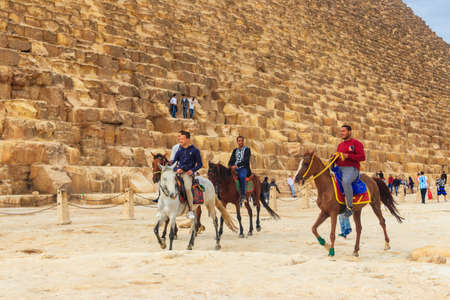 Cairo, Egypt - December 7, 2018: Group of tourists riding horses near pyramids of Giza in Cairo, Egyptのeditorial素材