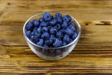 Fresh blueberry in glass bowl on a wooden tableの写真素材