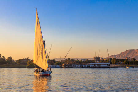 Luxor, Egypt - December 11, 2018: Felucca boats sailing on the Nile river in Luxor, Egypt. Traditional Egyptian sailing boatsのeditorial素材