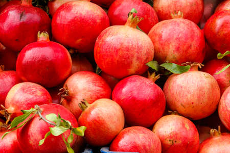 Heap of fresh pomegranates for sale in market. Background of pomegranate fruitsの写真素材