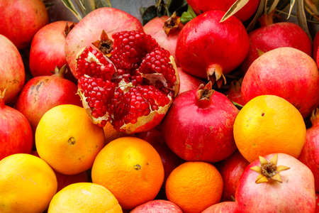 Heap of fresh pomegranates and oranges for sale in marketの写真素材