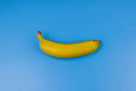 Yellow banana on pastel blue background. Top view, flat lay, minimal designの写真素材