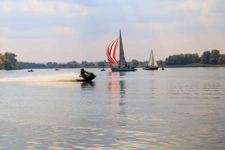 Kremenchug, Ukraine - September 28, 2019: Jet ski and sailboats sailing on the Dnieper river in...