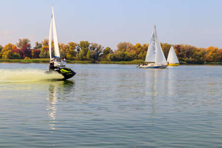 Kremenchug, Ukraine - September 28, 2019: Jet ski and sailboats sailing on the Dnieper river in...