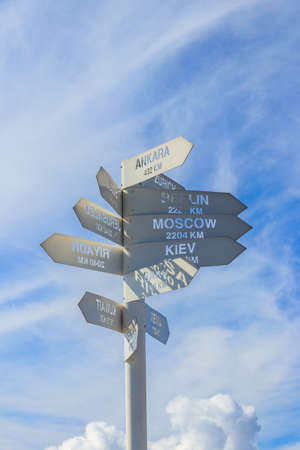 Sign indicating the directions and distances to major cities in the world on observation deck on a...