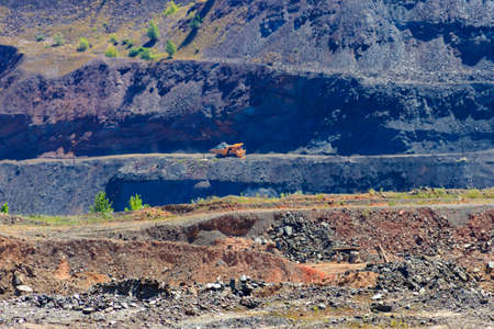 Huge mining dump truck working in iron ore quarry. Mining industry