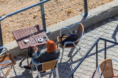 Ginger woman relax in cafe on a top of Tahtali mountain near Kemer, Antalya Province in Turkeyの写真素材