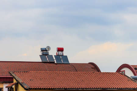 Solar water heaters on a residential house rooftop. Renewable energy for houseの写真素材