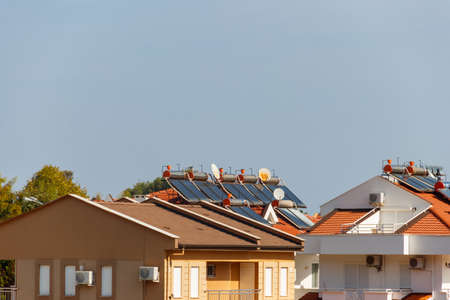 Solar water heaters on a residential house rooftop. Renewable energy for houseの写真素材