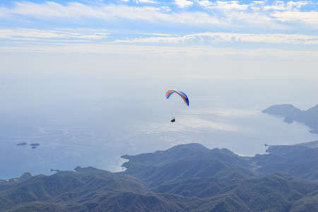 Paragliders flying from a top of Tahtali mountain near Kemer, Antalya Province in Turkey. Concept of active lifestyle and extreme sport adventureの写真素材