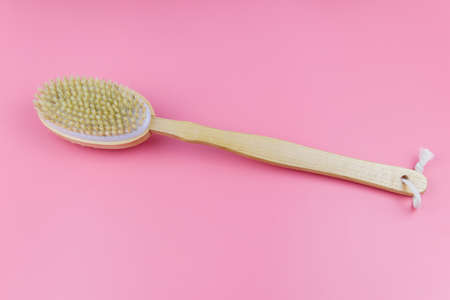 Massage brush on a pink background