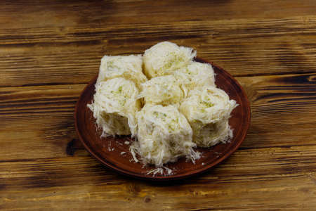 Traditional Turkish dessert Pismaniye with pistachios on wooden tableの写真素材