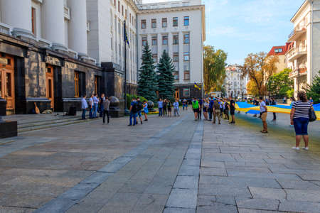 Kiev, Ukraine - August 23, 2019: People holding a huge ukrainian flag near Presidential administration during Day of Flag of Ukraine celebration in Kiev, Ukraineのeditorial素材