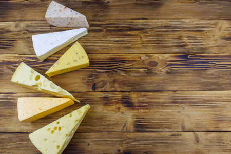 Set of various types of cheese on wooden table. Top view, copy spaceの写真素材