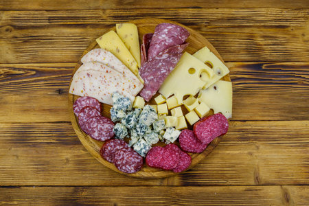 Antipasti platter with assortment of italian salami and cheese on wooden table. Top view