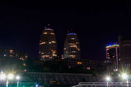 View of beautiful modern buildings, skyscrapers and towers of the night big city in Dnipro, Ukraine