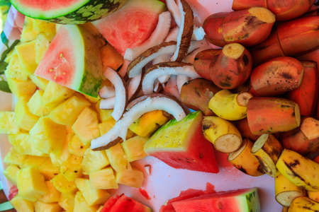 Platter with cut tropical fruits: pineapple, bananas, coconut, watermelonの写真素材