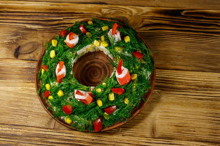 Salad Christmas wreath on a wooden table. Top viewの写真素材