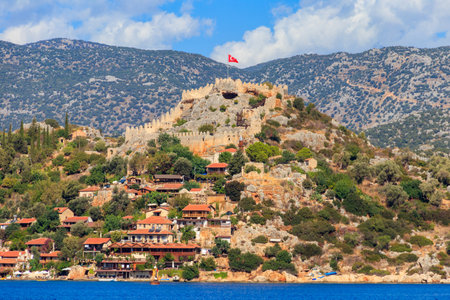 View of ancient Lycian town Simena with fortress on a mount on the coast of the Mediterranean sea in Antalya Province, Turkeyのeditorial素材