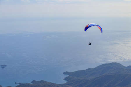 Paragliders flying from a top of Tahtali mountain near Kemer, Antalya Province in Turkey. Concept of...