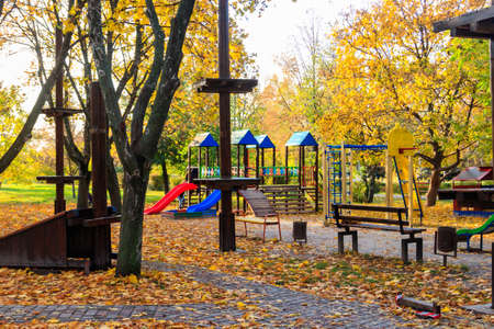 Colorful playground equipment for children in public park at autumnの写真素材