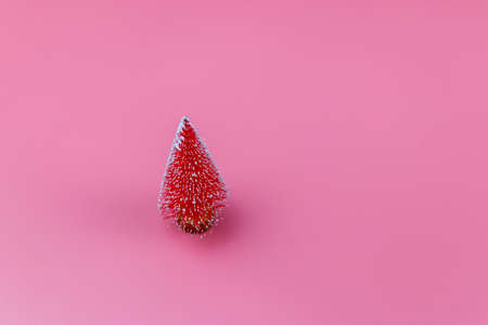 Christmas tree on a pastel pink background. Christmas or New Year concept. Minimal design