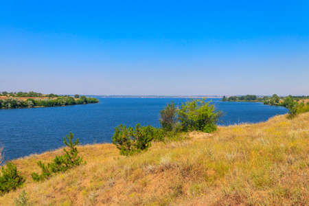 Summer landscape with beautiful river, green trees and blue skyの写真素材