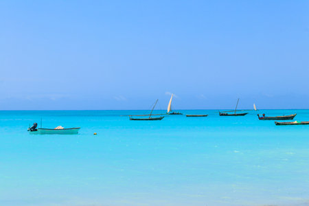 View of tropical sandy Nungwi beach and traditional wooden dhow boats in the Indian ocean on Zanzibar, Tanzaniaの写真素材