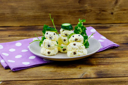 Christmas salad in the shape of snowmen and Christmas tree on a plate on wooden tableの写真素材