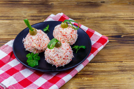 Appetizer of crab-cheese balls made in a shape of Christmas baubles on wooden tableの写真素材