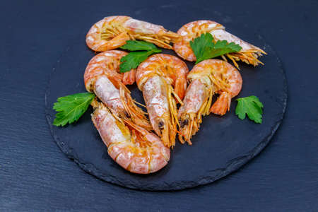 Boiled large langoustines on a black slateの写真素材