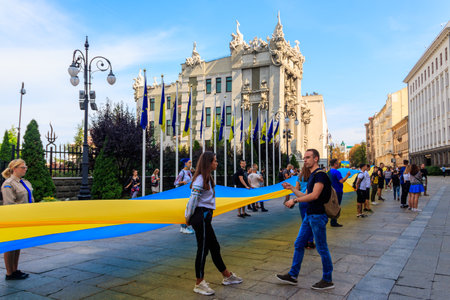 Kiev, Ukraine - August 23, 2019: People holding a huge ukrainian flag near Presidential administration during Day of Flag of Ukraine celebration in Kiev, Ukraineのeditorial素材